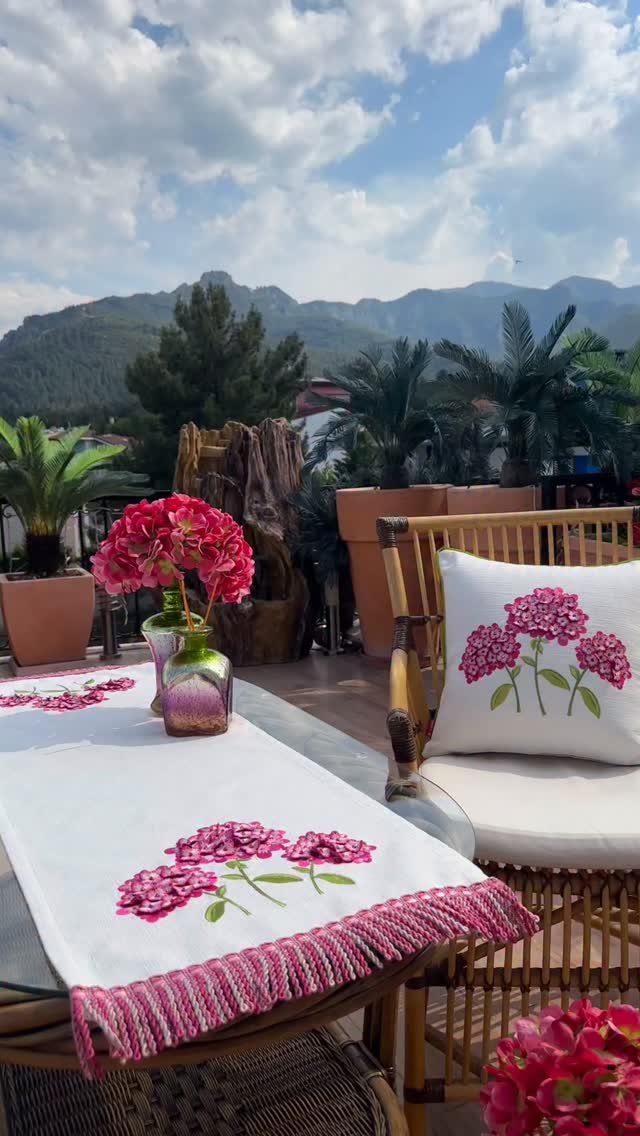 Baysal Home Pembe Ortanca Runner ve Kırlent: Pembe ortanca nakışıyla masa örtüsü ve kırlenti birlikte gösteren yazlık set görünümü.